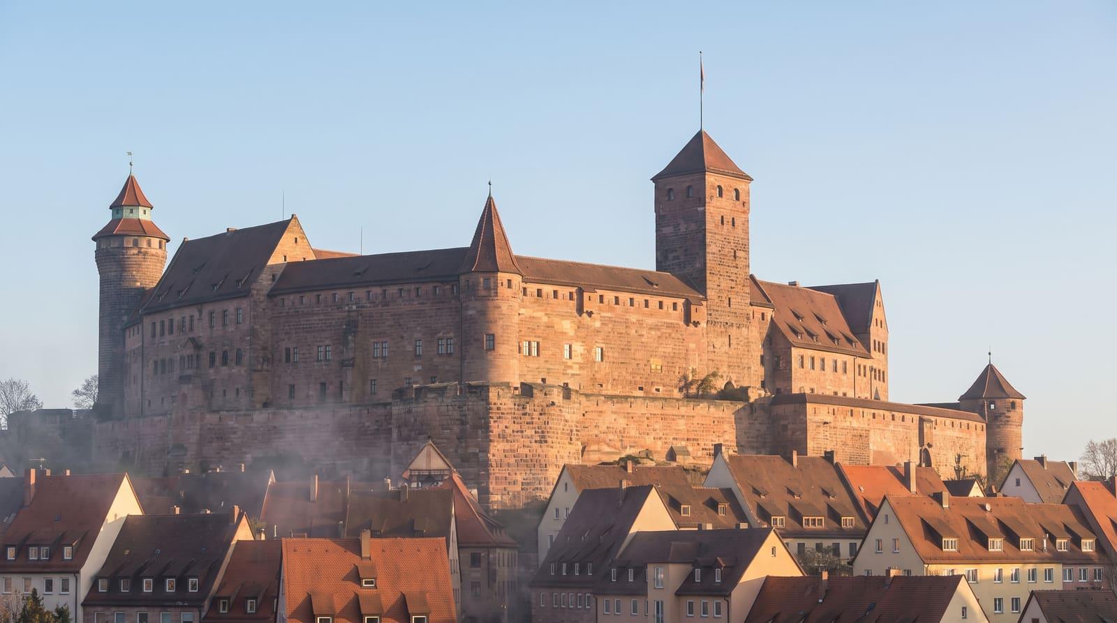 Die Nürnberger Kaiserburg über der Altstadt im ersten Morgenlicht als Sinnbild für ein beständiges, solides Fundament
